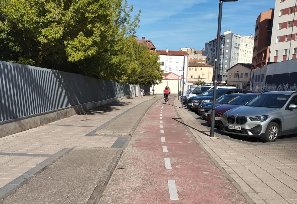 Carril bici urbano en Burgos junto a zona de aparcamiento.