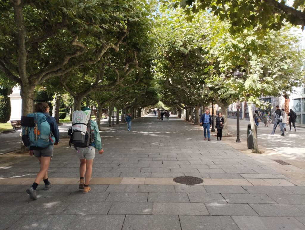 Paseo del Espolón en Burgos con dos peregrinos caminando