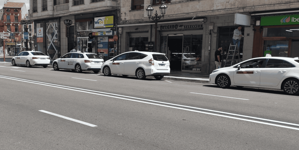Parada de taxis en la Plaza Vega de Burgos con varios vehículos estacionados.